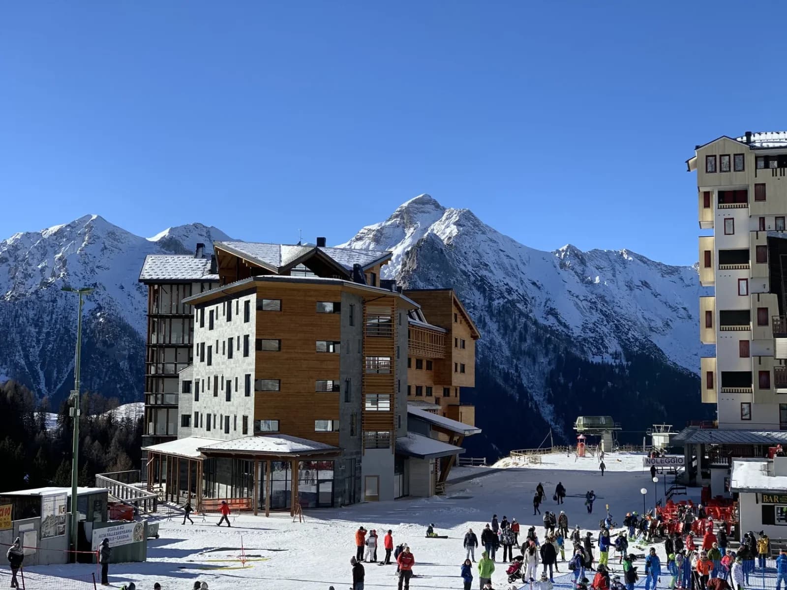 Il piazzale degli alberghi con gli sciatori in partenza