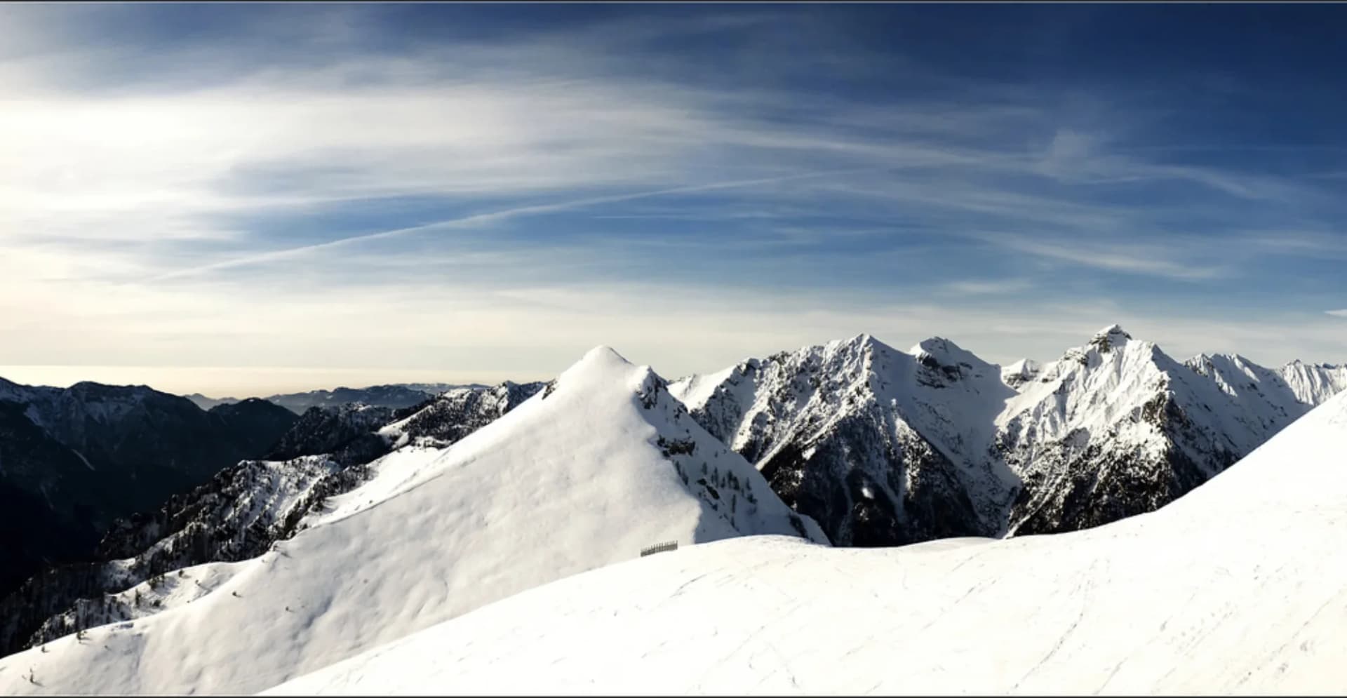 Il crinale innevato in controluce, sopra il mare di nuvole