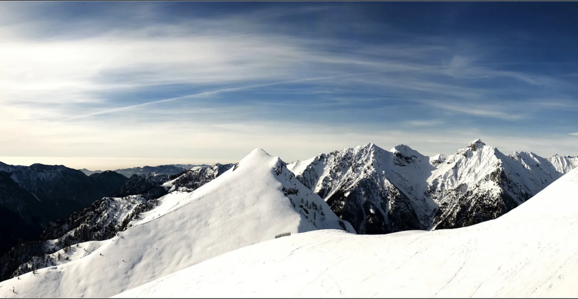 Il crinale innevato in controluce, sopra il mare di nuvole